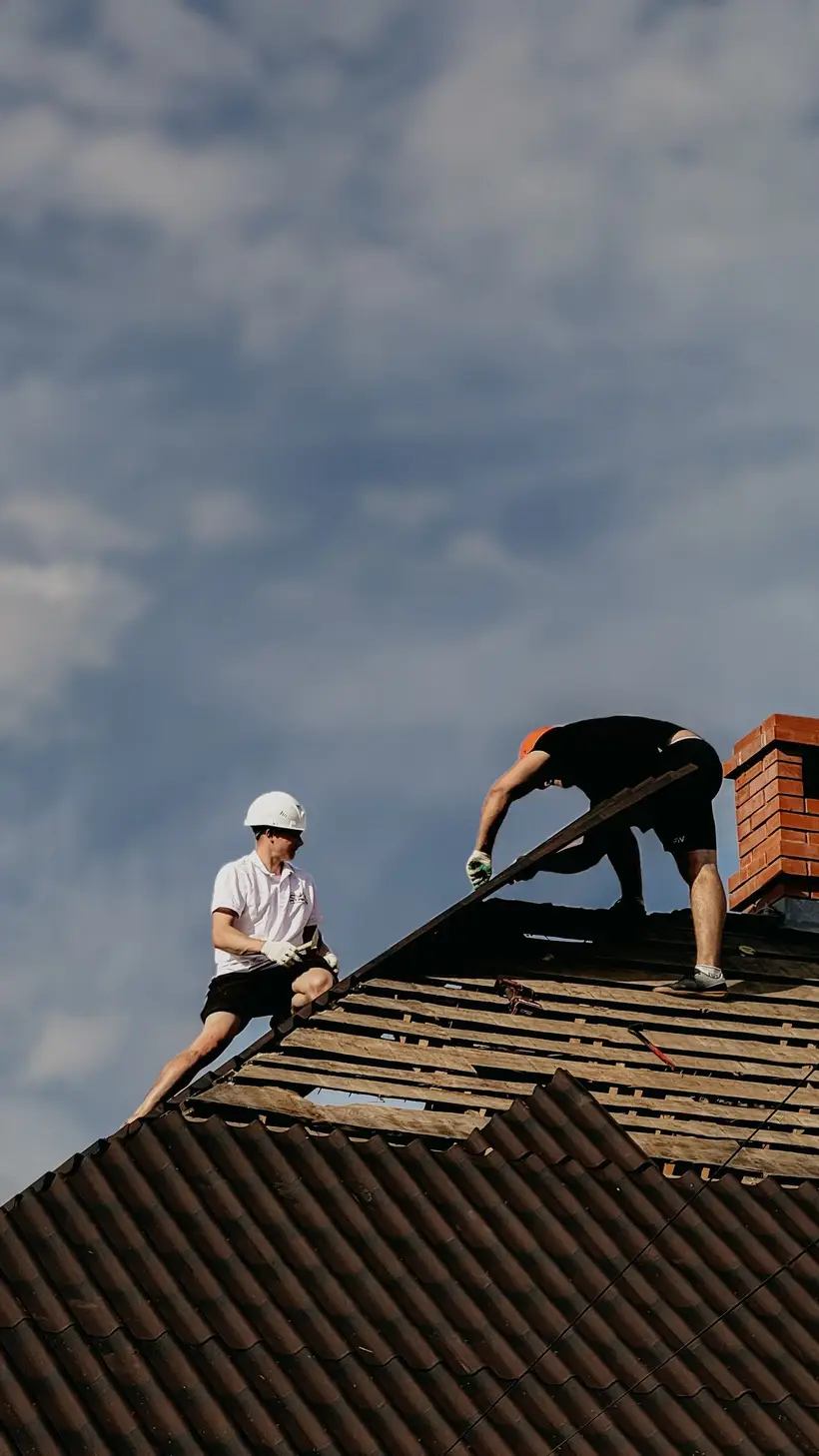Roofers working near a roof ridge
