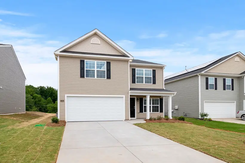 Two-story home with a wide driveway and lawn