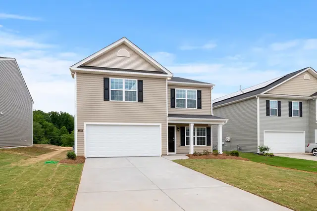 Two-story home with a wide driveway and lawn