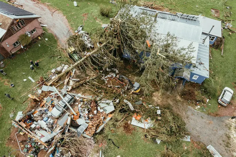 Aerial view of a fallen tree and debris on a damaged home